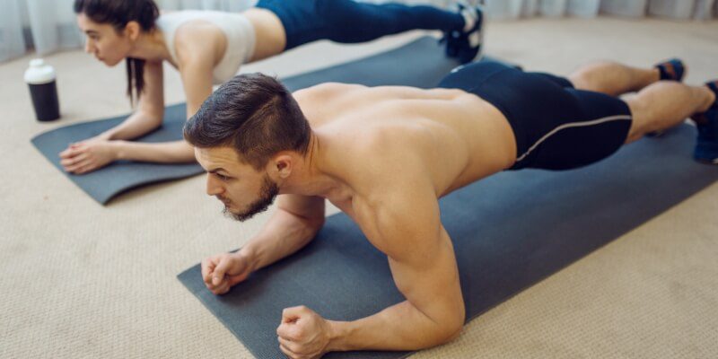 Adults doing planks in a living room area