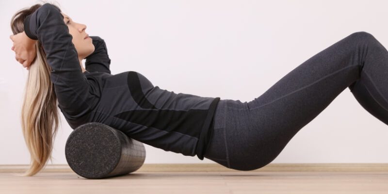 Woman using a foam roller on her back in a home exercise routine